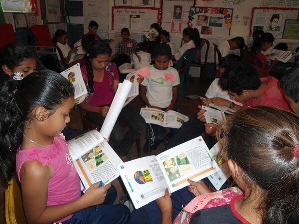 Niños leyendo documento ODS